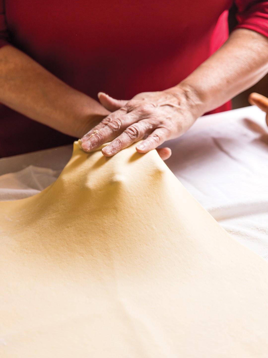 Lisa Haggstrom stretching the potica dough