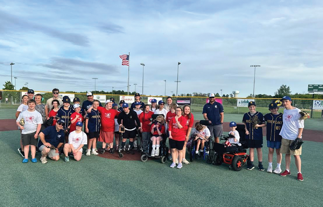 A Miracle League team poses with their buddy team at a game in King Park in Lakeville.