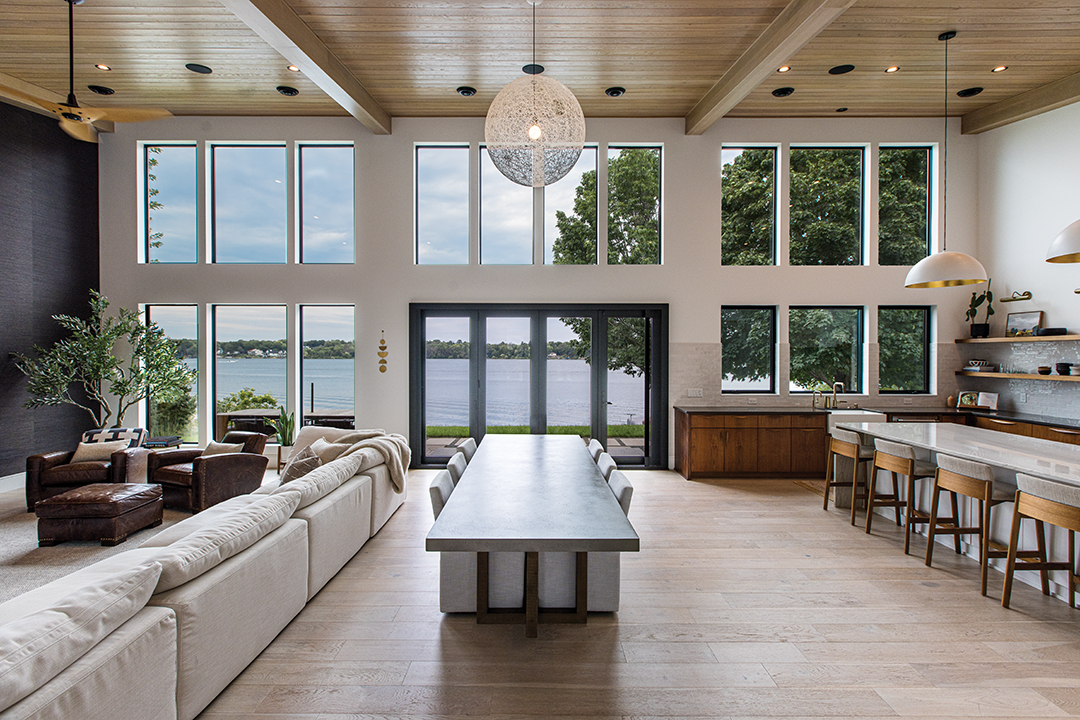 A white oak-paneled ceiling helps create a cohesive flow between the kitchen, dining room and main living room. A neutral palette helps foster a sense of calm.